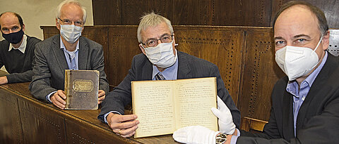 Übergabe der handschriftlichen Protokollbände im historischen Röntgen-Hörsaal der FHWS. Im Bild (v.l.): Utz Fischer, Manfred Gessler und Manfred Schartl von der PMG sowie Hans-Günter Schmidt, Leiter der UB. 