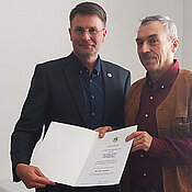 Dirk Ahrens-Lagast (rechts) bekommt vom Präsidenten des Deutschen Imkerbundes, Torsten Ellmann, die Urkunde für den Züchterpreis überreicht. 